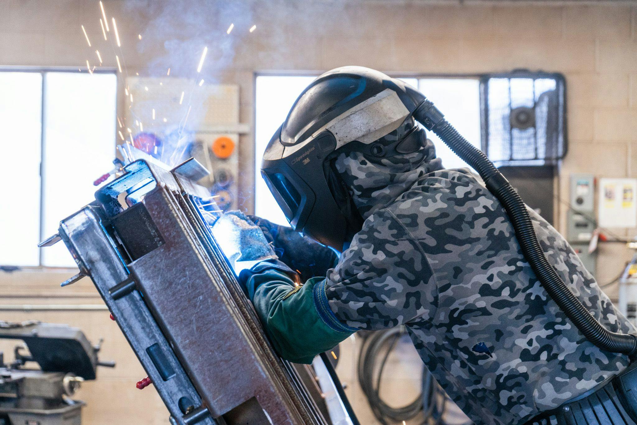 An Escapod team member welding the frame for a TOPO2, an offroad trailer.