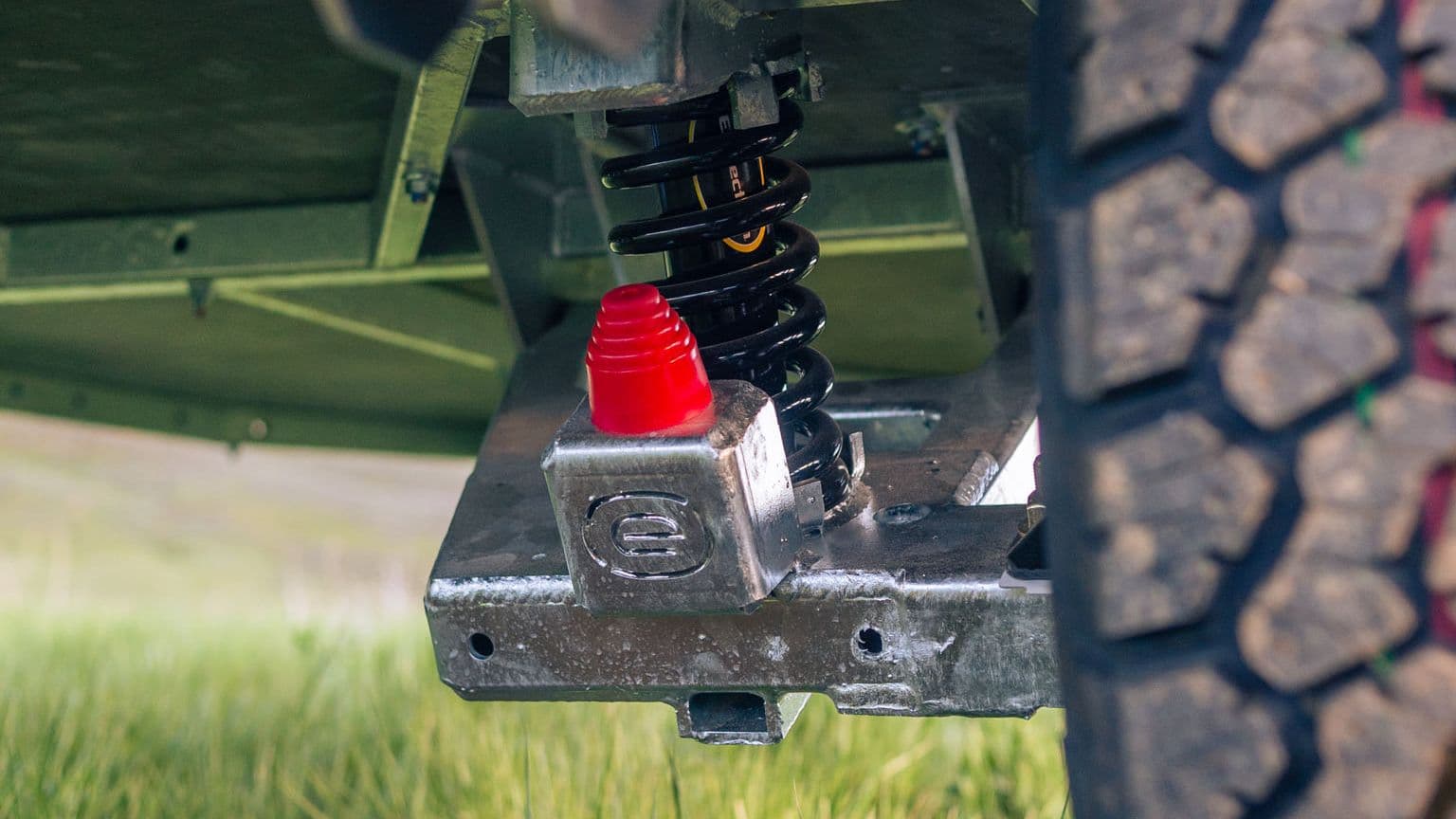 Close-up of the FREERIDE Suspension System on an Escapod TOPO2 trailer, showing its durable shock-in-spring off-road setup.