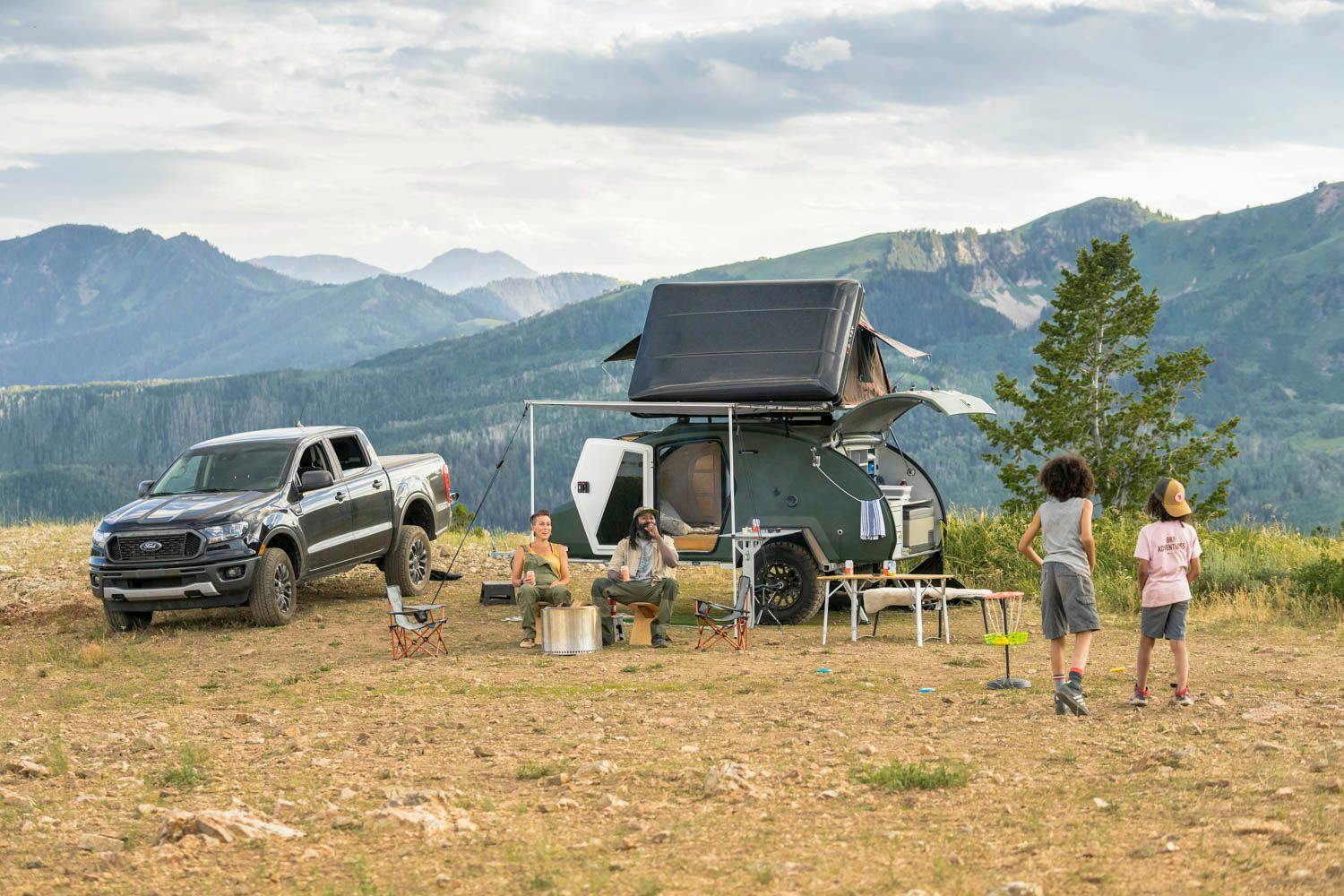 A family enjoying some campsite games in front of their teardrop camper.