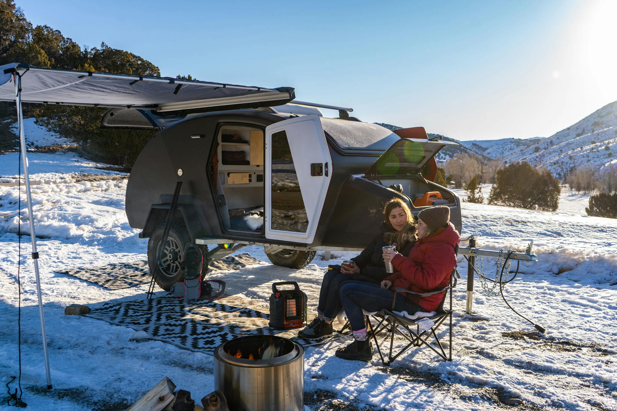 Winter camping in an adventure camper, enjoying time around the fire.