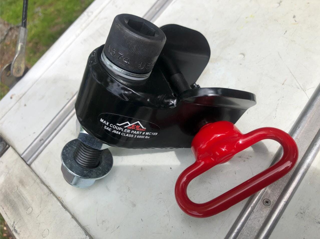 The receiving end of a maxx coupler articulating hitch with a red pin.