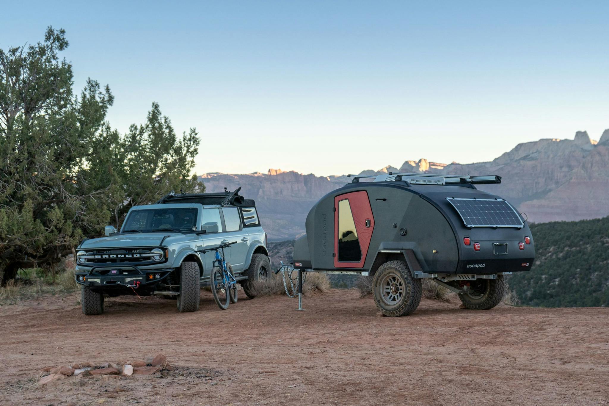 A blue teardrop trailer with fire doors parked in Gooseberry Mesa with a Ford Bronco.
