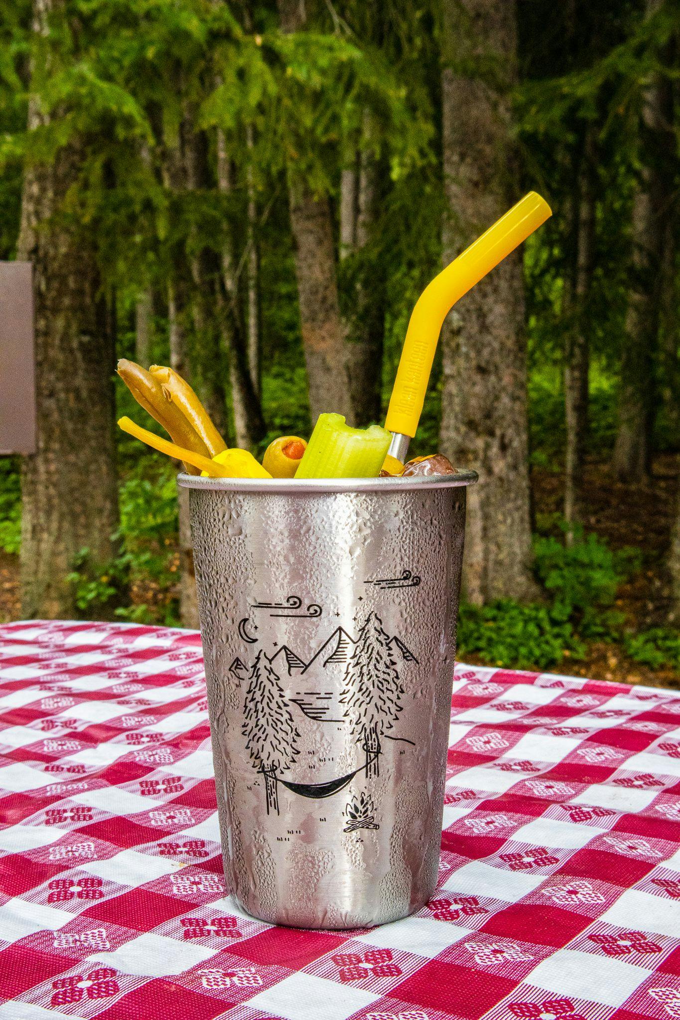 A camp cocktail called the Bloody Maria placed on a picnic table.