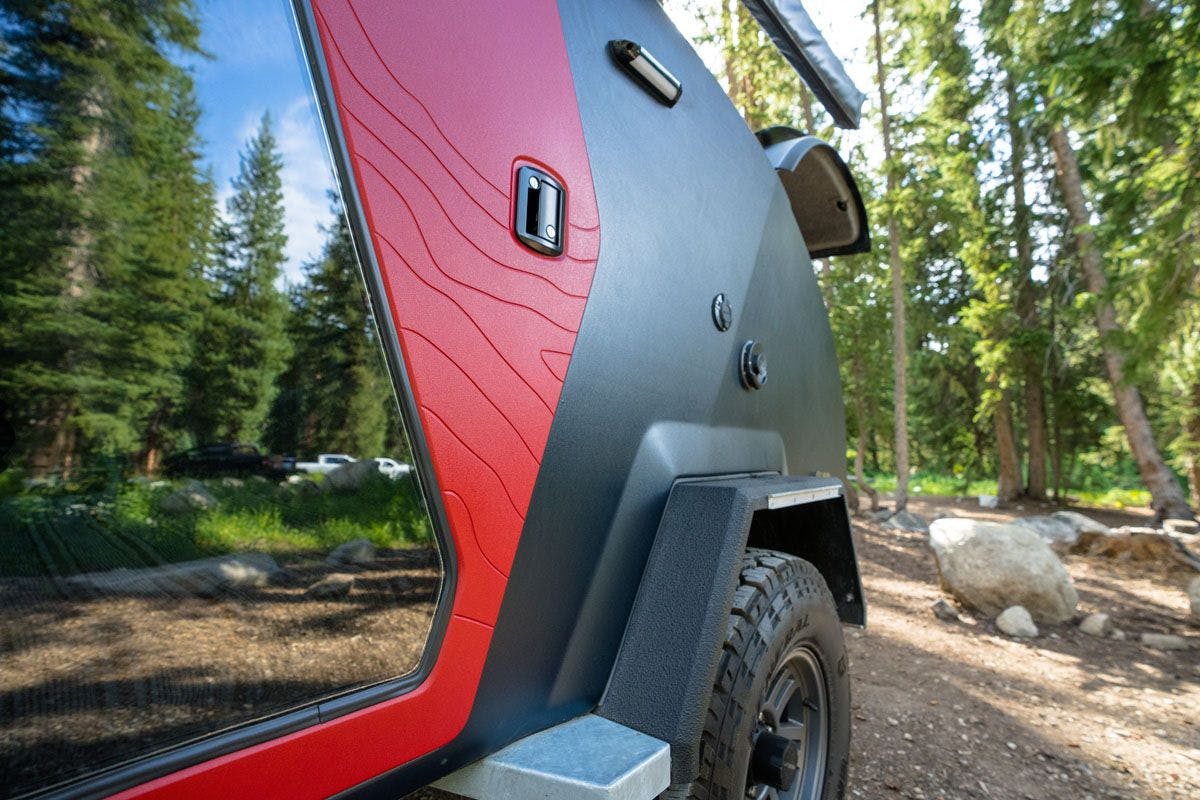 The door of a teardrop camper that has topographical lines from mountain ranges in Utah.