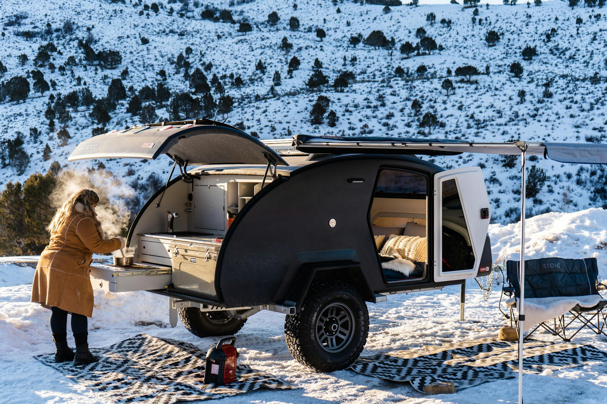 Winter camping in an adventure camper, cooking a camp meal.