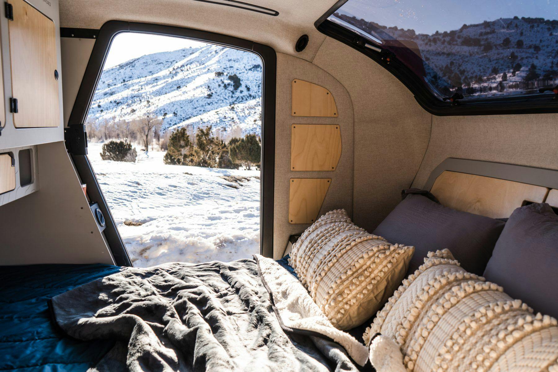 A cozy interior of a teardrop trailer during the winter months.