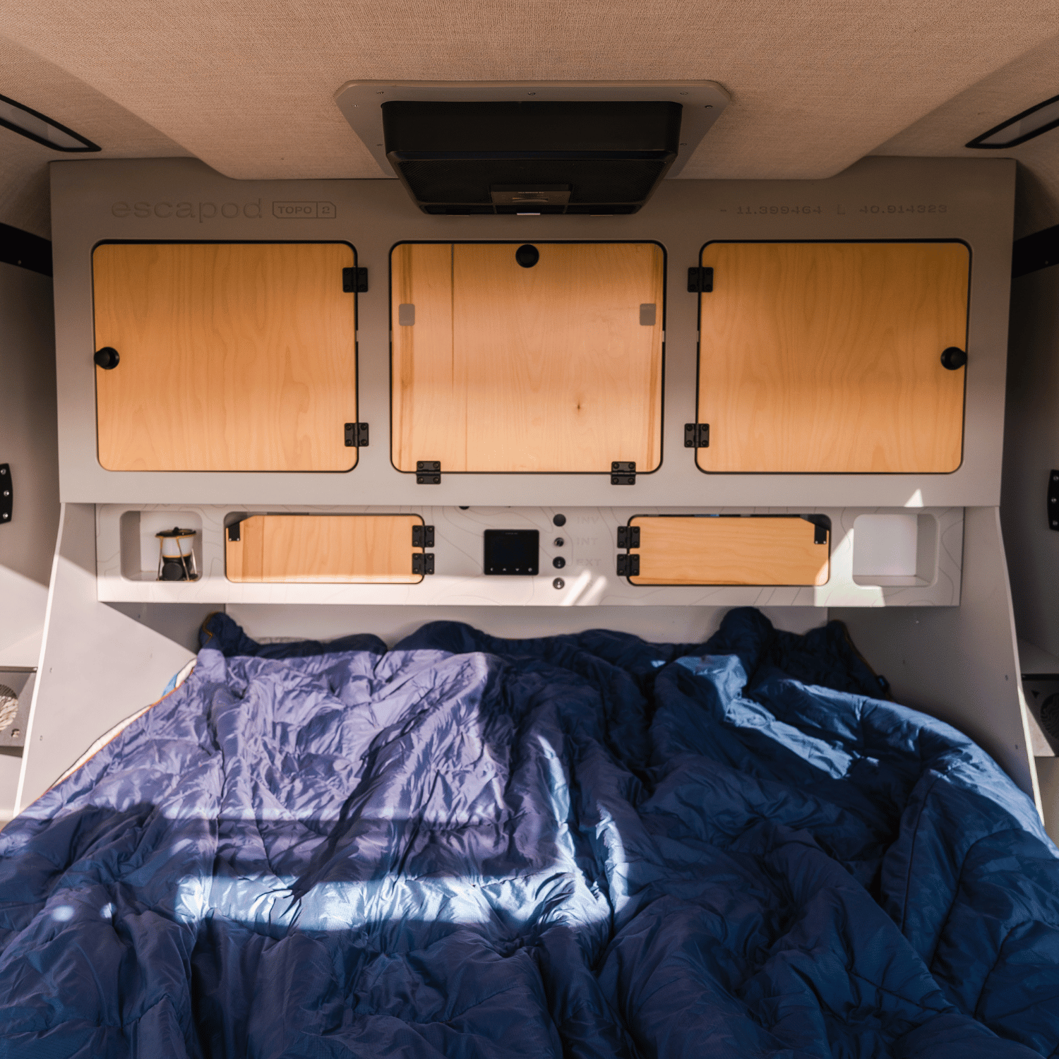 Interior of a teardrop trailer, displaying the birch cabintery of the TOPO2.