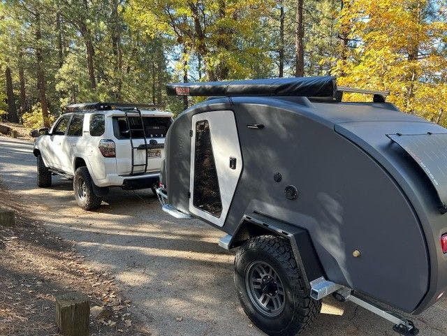 A storm grey TOPO2, an offroad adventure trailer hooked up to a Toyota 4Runner.