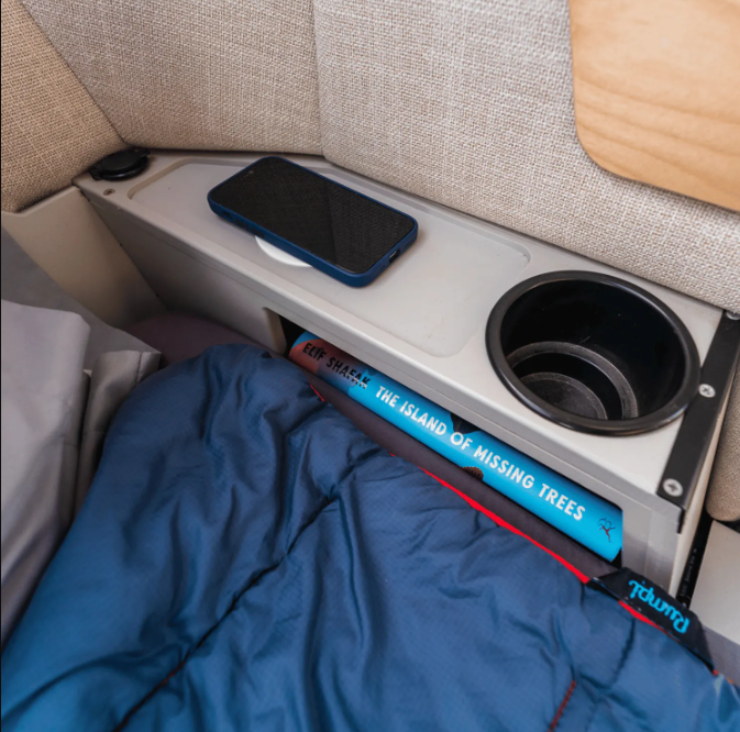The nightstand in an adventure trailer on display, showing the wireless charging feature in the TOPO2,